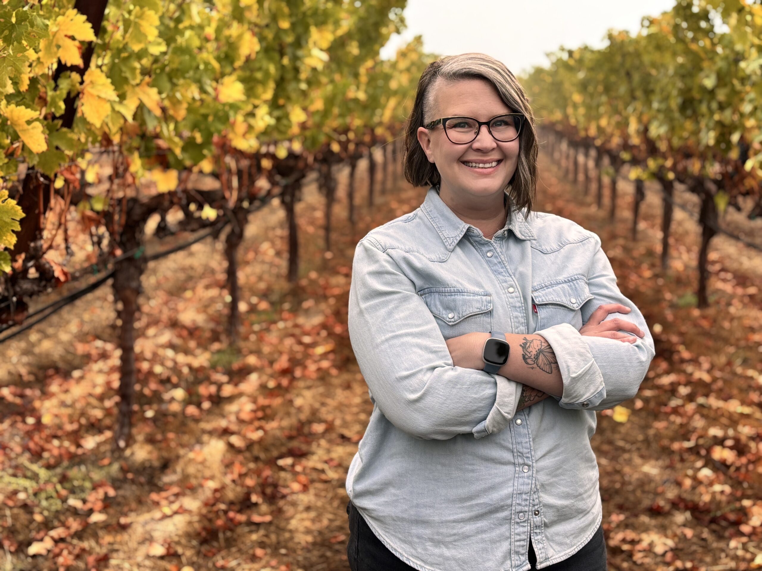 Emily Hanes, Winemaker, standing in vineyard